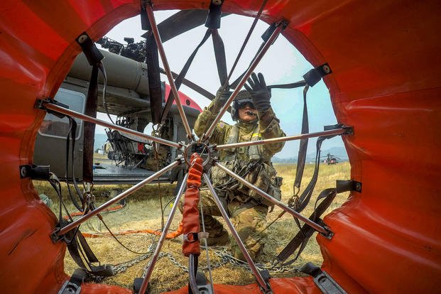 Army Staff Sgt. Ge Xiong checks a 600-gallon water bucket before a mission at the Mendocino Complex Fires in Lake, Colusa and Mendocino counties, Calif., Aug. 10, 2018. Army National Guard photo by Staff Sgt. Eddie Siguenza