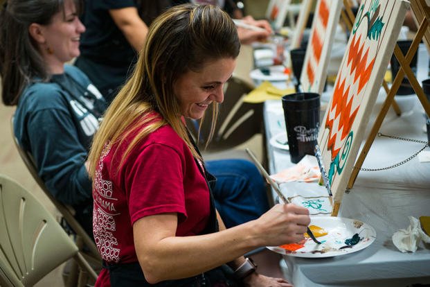 A military spouse loads her paintbrush during a Painting with a Twist event, Oct. 21, 2017, at Moody Air Force Base, Ga. (U.S. Air Force photo/Erick Requadt)