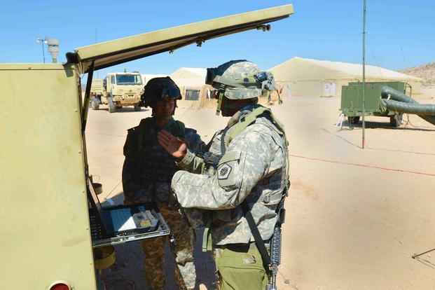 U.S. Army 1st Lt. Dat Dang and Sgt. Maurice Wendorf of the 98th Expeditionary Signal Battalion discuss the functions of a Supply Terminal Trailer at Fort Irwin, California, on May 10, 2016. The STT is a satellite that can provide online capabilities for frontline troops' computer systems anywhere in the world. (U.S. Army photo by Spc. Adam Parent)