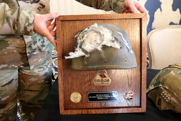 Staff Sgt. Steven McQueen shows a closer view of the hole the enemy rifle round made when it tore into the Enhanced Combat Helmet. (Military.com/Matthew Cox)