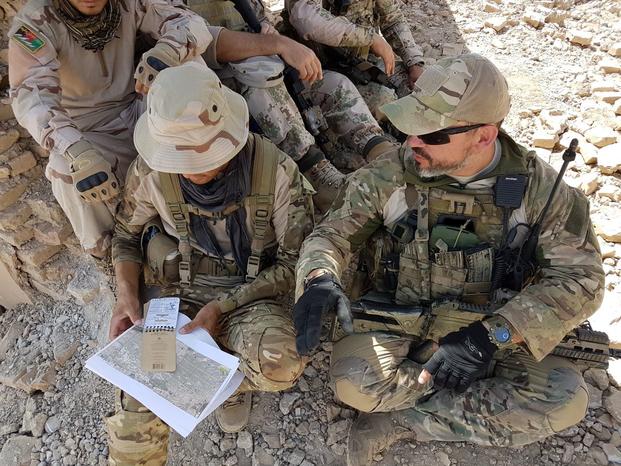 A coalition Joint Terminal Attack Controller (JTAC) advisor trains two Afghan Territorial Force 444 members from General Command of Police Special Unit (GCPSU) to identify targets on the battlefield during an air-to-ground integration exercise at Tarnak range, Kandahar province, Afghanistan, July 2018. (Marty Schaeffer/NATO Photo Released)