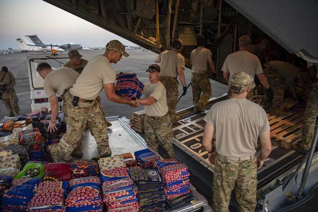 U.S. Airmen and Soldiers unload clothing from a C-130J Hercules assigned to the 75th Expeditionary Airlift Squadron, Combined Joint Task Force-Horn of Africa, at the airport in Beria, Mozambique, March 29, 2019. (U.S. Air Force/Tech. Sgt. Chris Hibben)