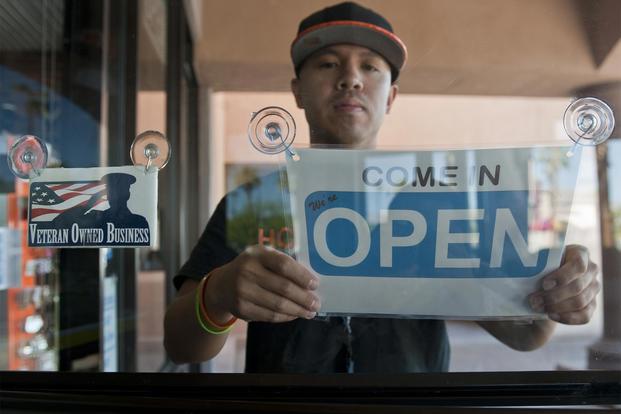 Retired Tech. Sgt. Alfredo Sibucao Jr. flips the open sign to his retail store in Las Vegas, June 22, 2015. Sibucao retired from the Air Force in 2014 and now owns and operates a small business in Las Vegas. (U.S. Air Force/Staff Sgt. Siuta B. Ika)
