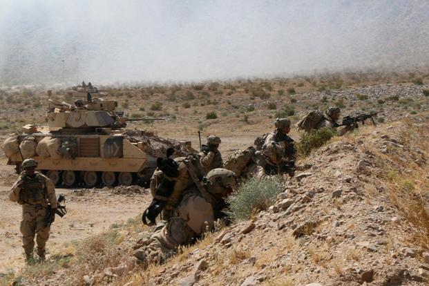 Infantrymen with the 2nd Armored Brigade Combat Team wait behind cover as a leader talks on the radio during the unit’s recent rotation at the National Training Center, Fort Irwin, California. (Matthew Cox/Military.com)