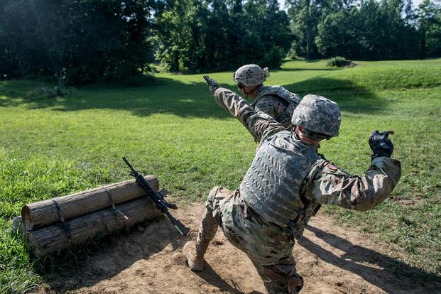 A cadet throws a practice grenade during ROTC Advanced Camp at Fort Knox, Kentucky as a sergeant from the 4th Infantry Division stands near to observe. (U.S. Army/Spc. Dana Clarke)