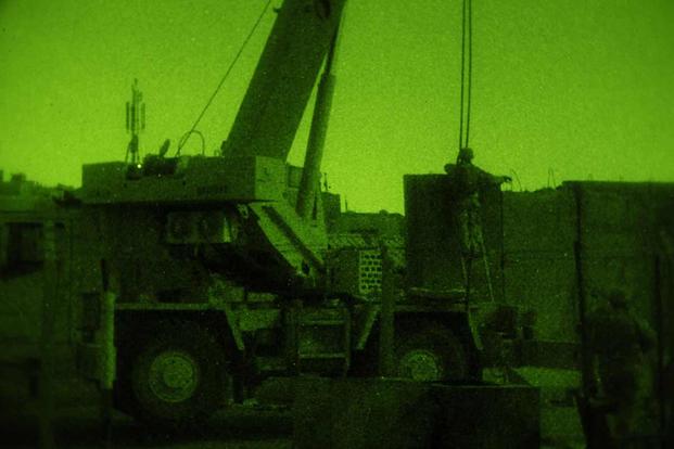 Engineers from 3rd BCT, 4th Infantry Division, use a crane in the southern portion of Sadr City to place barriers along the road to help increase security in the area. Photo by 1st Sgt. Adrian Cadiz