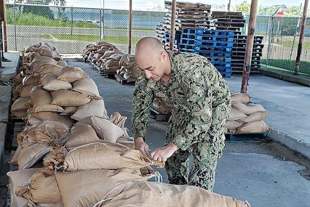 SW2 Matthew Koenig of Construction Battalion Maintenance Unit 202 fills sandbags to be placed around Naval Air Station Jacksonville, Florida, in preparation for Hurricane Dorian. Photo by Julie M. Lucas