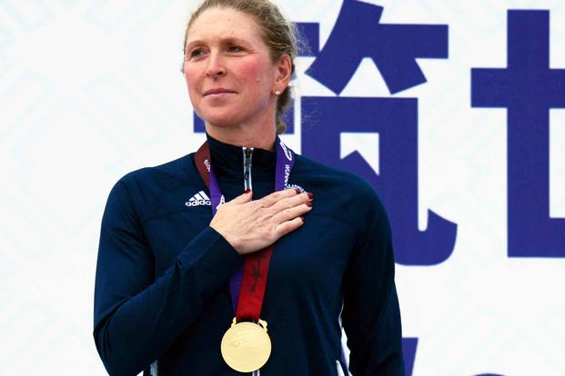 Air Force Reserve Maj. Judith Coyle listens to the U.S. national anthem after receiving the gold medal for placing first in the women's senior division of the Military World Games triathlon in Wuhan, China, Oct. 27, 2019. (Gary Sheftick/ U.S. Armed Forces Sports)