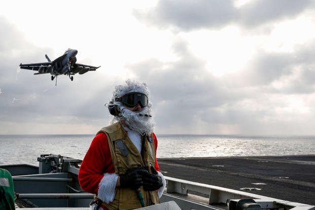 Santa Claus observes an F/A-18F Super Hornet on USS Abraham Lincoln