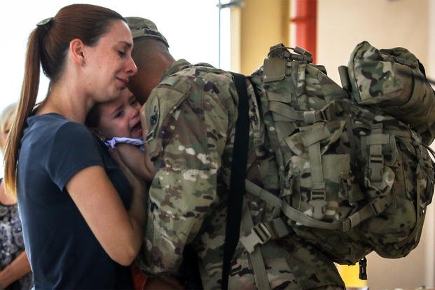 A military family hugs before deployment.