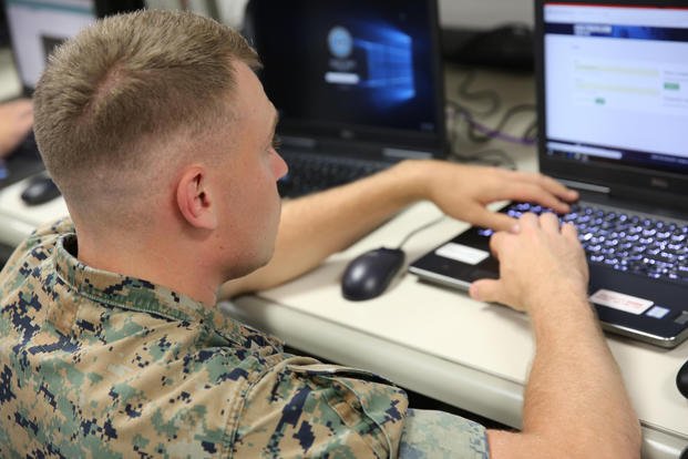A Marine works on his laptop