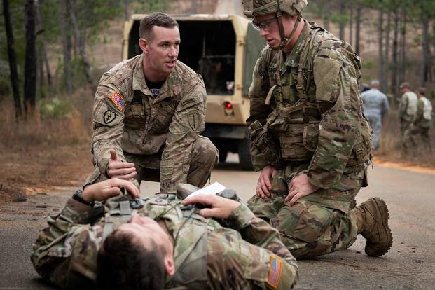 Medics talk about how to help a simulated victim’s leg injury.