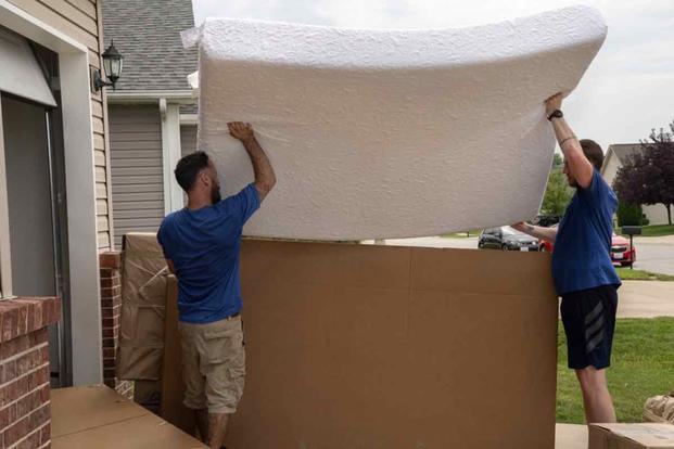 Movers pack a military members property into boxes and load it into crates to be transferred to a temporary storage facility in O'Fallon, Illinois, July 1, 2019. 