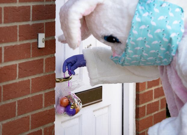 easter bunny putting a bag of eggs on front door