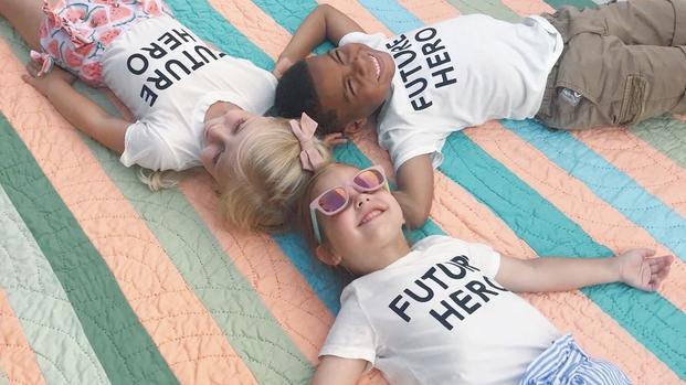 three small children laying on the floor in a circle