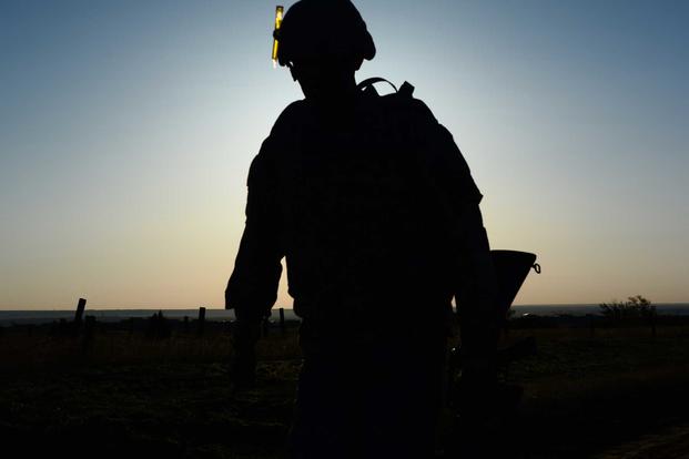 The silhouette of a soldier as he runs to the turnaround point of a 12 mile ruck march. 