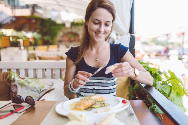 Smiling woman dining alone at restaurant