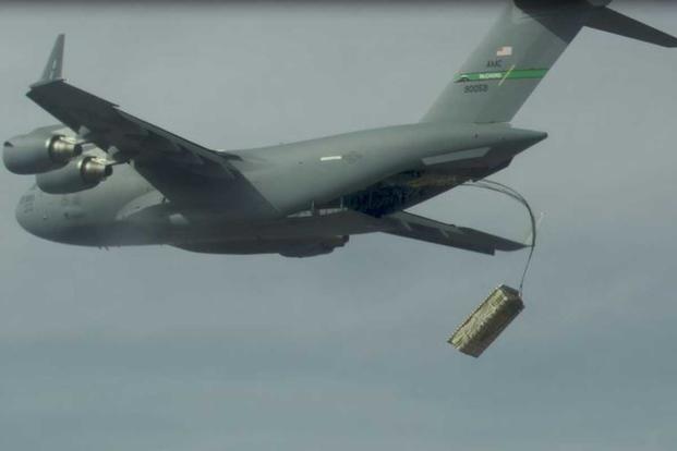 A high altitude airdrop of palletized munitions from a C-17.