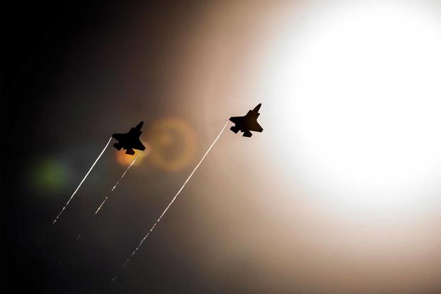 A pair of F-35 Lightning IIs pass under the sun while doing maneuvers to the Eglin Air Force Base runway. 
