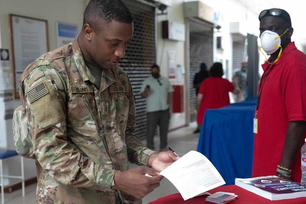 Soldier reads an absentee ballot while in the Post Exchange.