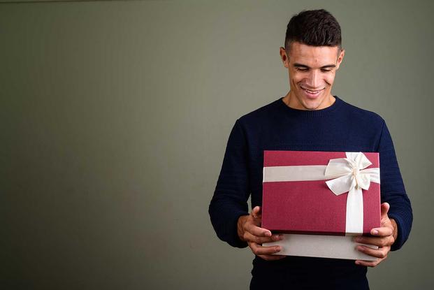 A man opens a gift | Military gift guide 2020