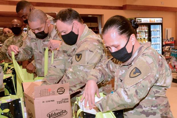 Fort Lee military leaders pack grocery bags with Thanksgiving meal items. 