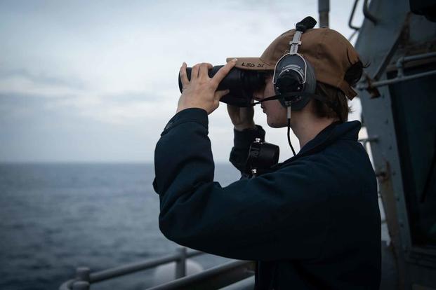 A sailor aboard the USS Oak Hill stands watch.