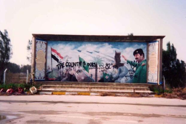 “The Country Is Ours,” signed “82nd.” The work of two soldiers sThe defaced mural of Saddam Hussein near Tallil Air Base.