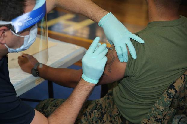 A U.S. Marine receives his first dose of the COVID-19 vaccine.