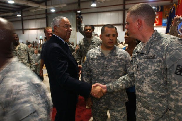 Retired Gen. Colin Powell shakes hands with a soldier.