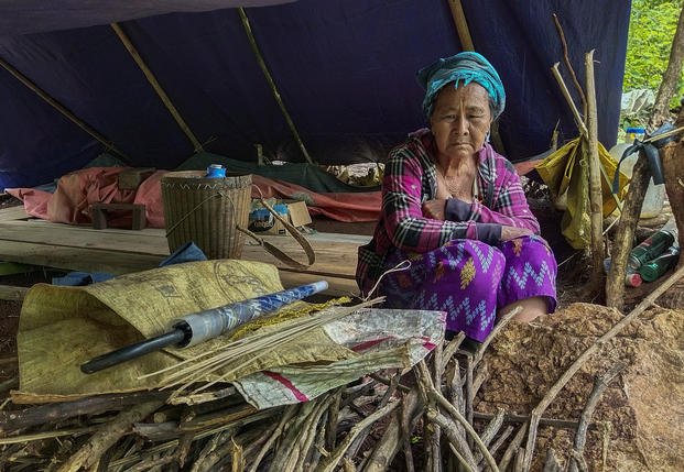 A woman sits inside her makeshift tent in Myanmar.