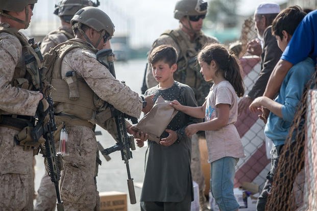 Marines with Special Purpose MAGTF - Crisis Response - Central Command guide evacuees on to a United States Air Force Boeing C-17 Globemaster III