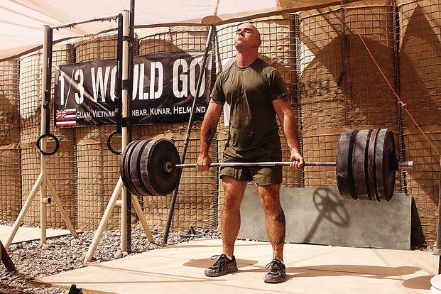Completing a deadlift during military workout.