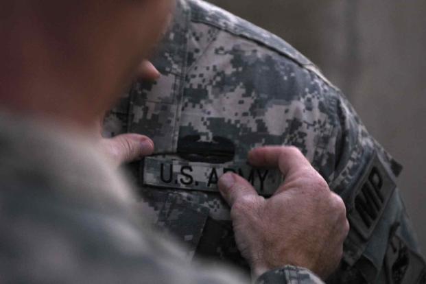 Combat Action Badge pinned on an MP during a ceremony at Camp Liberty