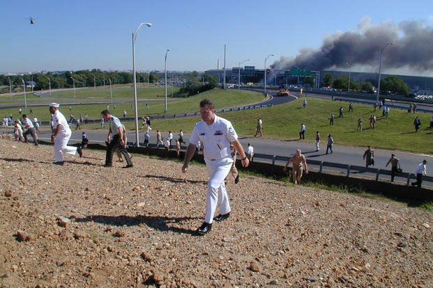Pentagon employees walk away from the building along VA-27 S Washington Blvd following the attack, 11 September 2001.