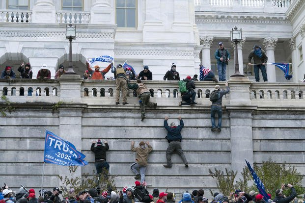 Insurrectionists scale the west wall of the U.S. Capitol in Washington
