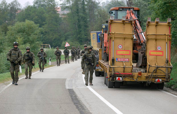 Polish soldiers pass through barricades as they patrol near a northern Kosovo border crossing.
