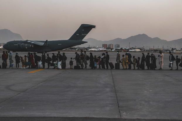 Afghan evacuees wait to board a Boeing C-17 Globemaster III
