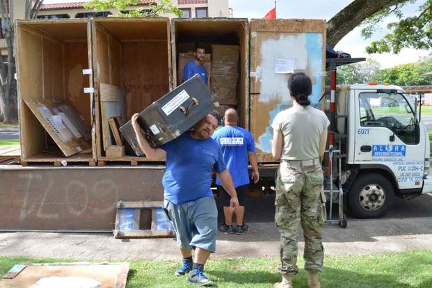 U.S. Army soldier supervises the delivery and unpacking of her household items