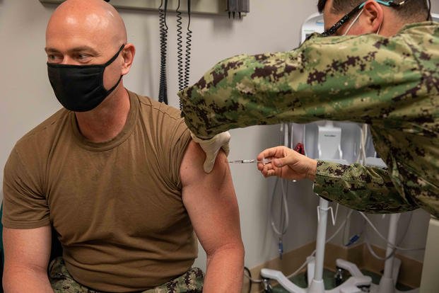 Command Master Chief Shawn Isbell, assigned to the amphibious assault ship USS Bataan (LHD 5), receives his second injection of the Covid-19 vaccine.