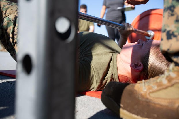 A Marine executes a floor press.
