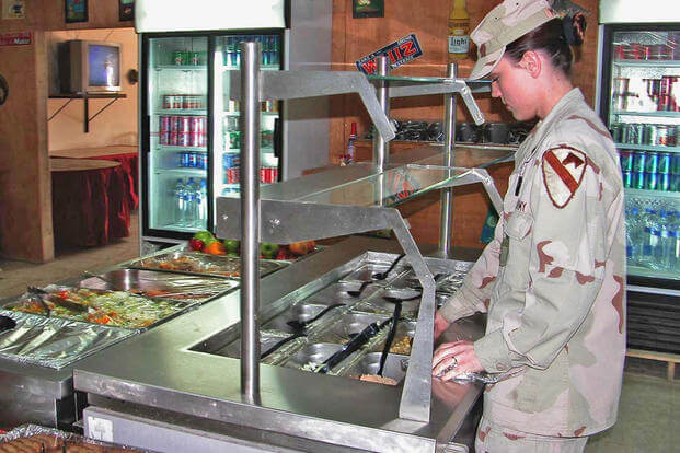 A food services specialist prepares the salad bar.