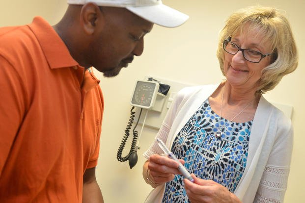 A diabetes nurse educator reviews insulin pen use with a patient.