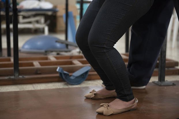 A patient practices bending her knees at a clinic in Comayagua, Honduras.