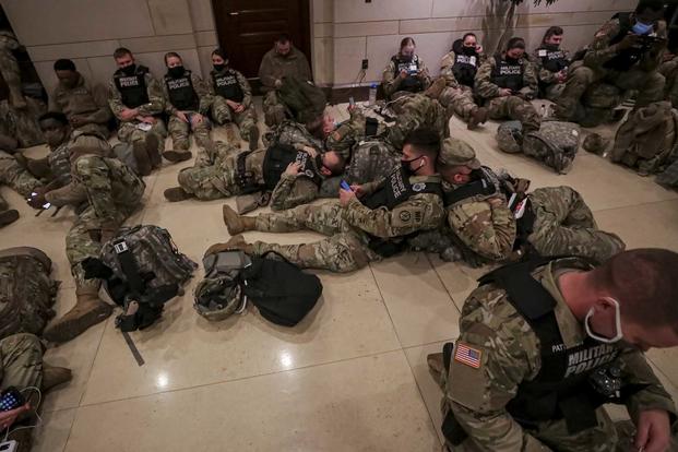 U.S. soldiers rest inside the visitors center at the U.S. Capitol