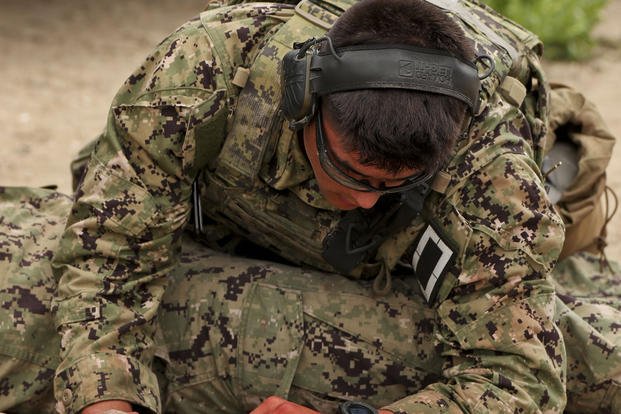 A Special Warfare Combatant-craft Crewman (SWCC) candidate assesses a simulated casualty during a training exercise.