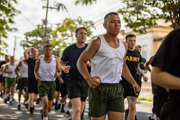 U.S. and Brazilian soldiers run.