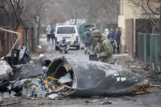 A Ukrainian Army soldier inspects fragments of a downed aircraft in Kyiv, Ukraine