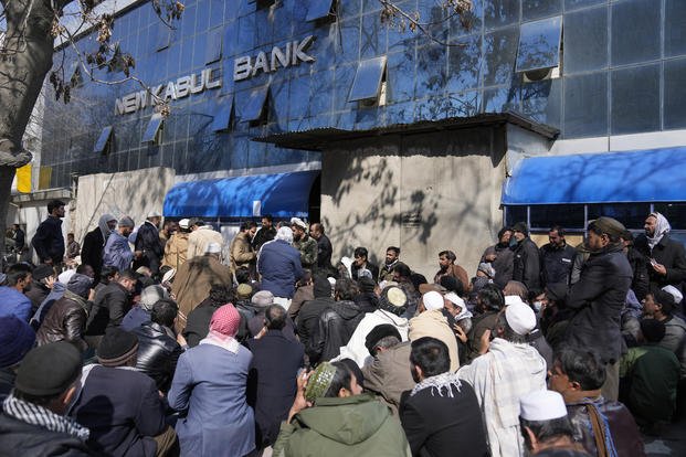 Afghan wait to enter a bank, in Kabul, Afghanistan