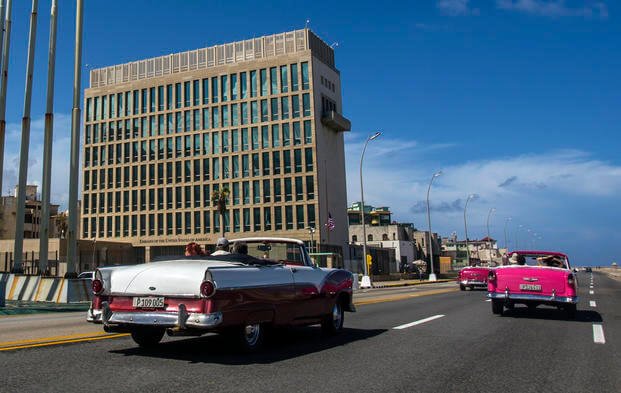 Tourists ride classic convertible cars on the Malecon beside the U.S. Embassy in Havana, Cuba